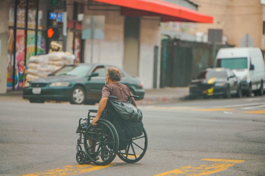 Veteran crossing street in a wheelchair