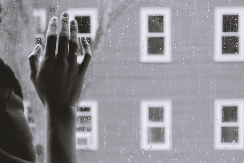 hand against rainy window